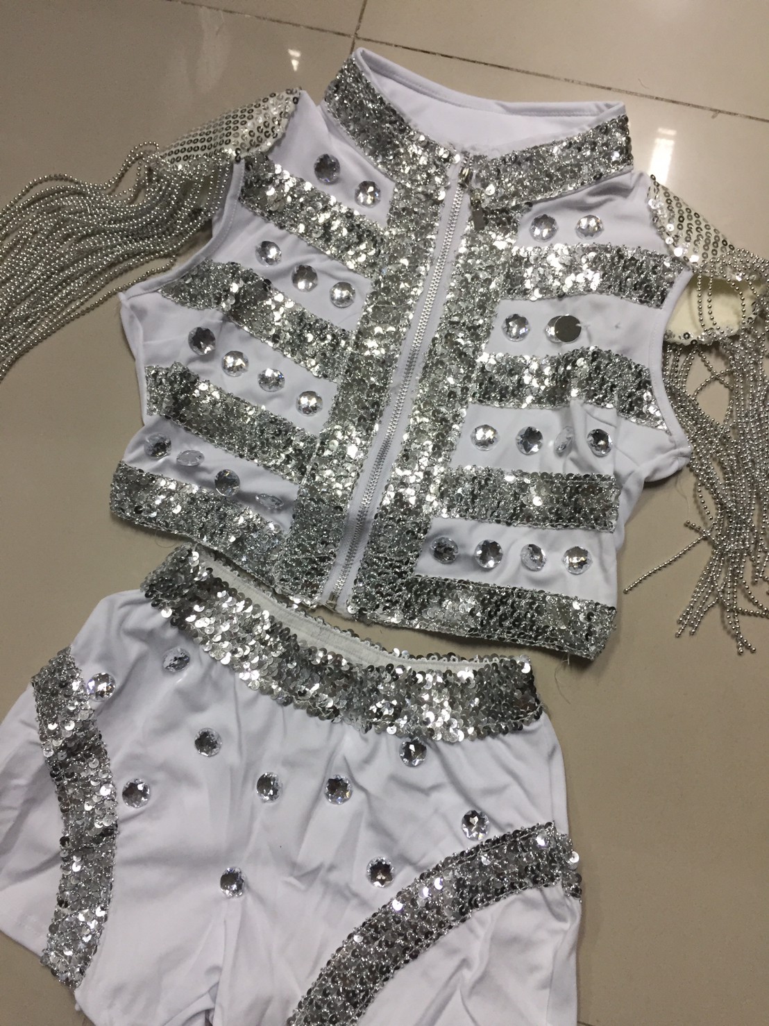 ชุดแฟนซี - ชุดพีอาร์ พริตตี้ เสื้อคร๊อปเอวลอยสีขาว แต่งเพชร เกล็ดปลาและพู่โซ่ที่ไหล่ กางเกงขาสั้น